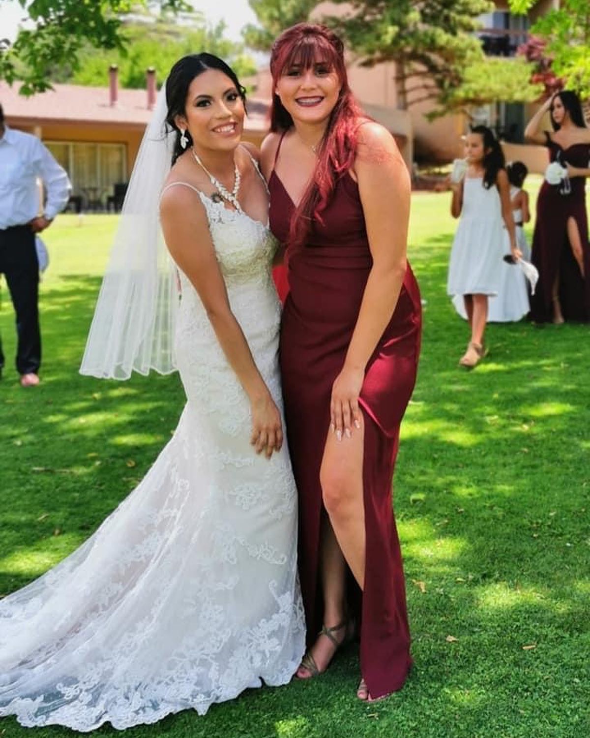 Brunette bride in white wedding dress with bridesmaid