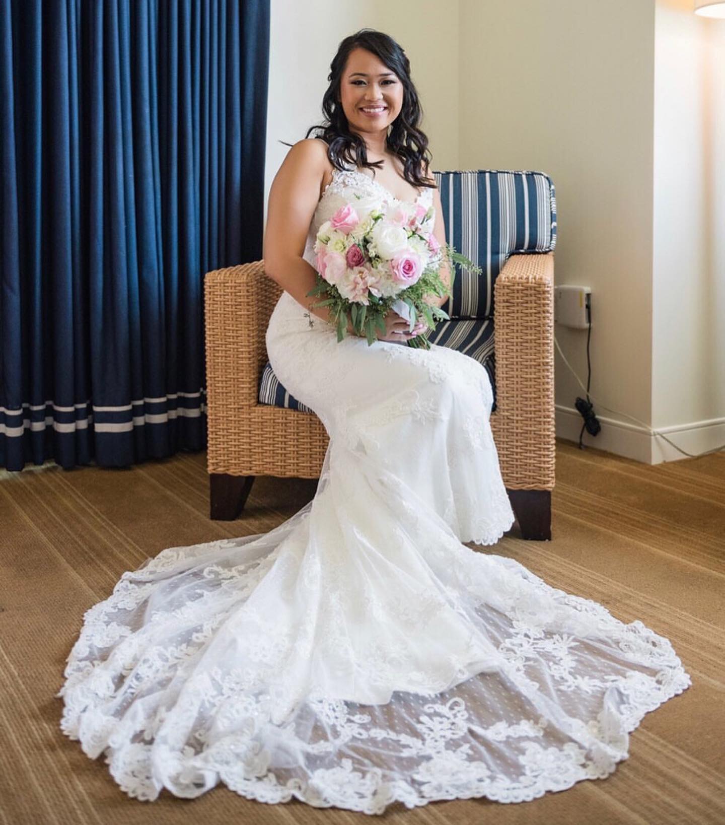 Brunette bride in white wedding dress sitting with flowers