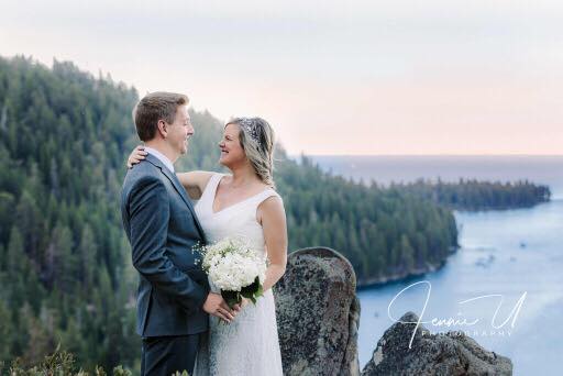 Bride in white wedding dress and groom at rocky seaside