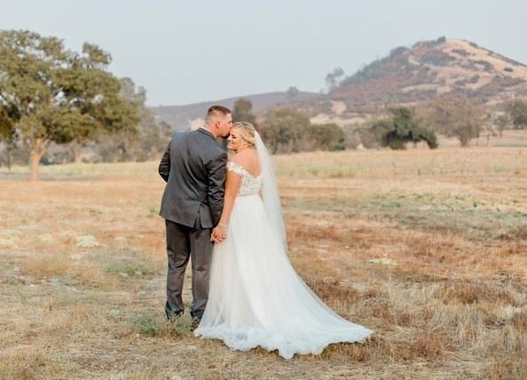 Blonde bride in white wedding dress and Groom at countryside