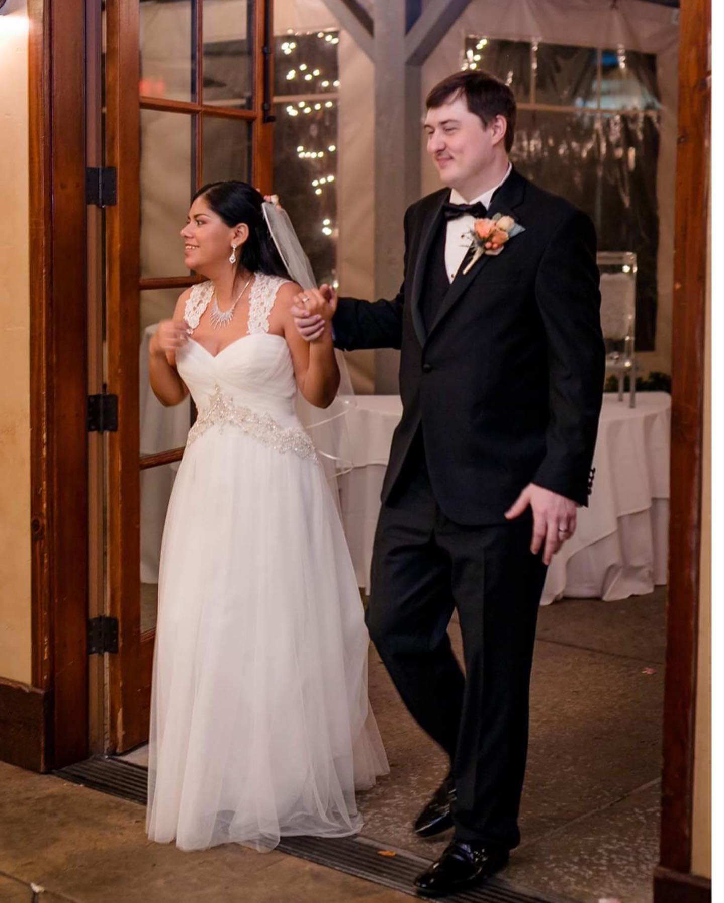 Brunette bride in white wedding dress walking with groom