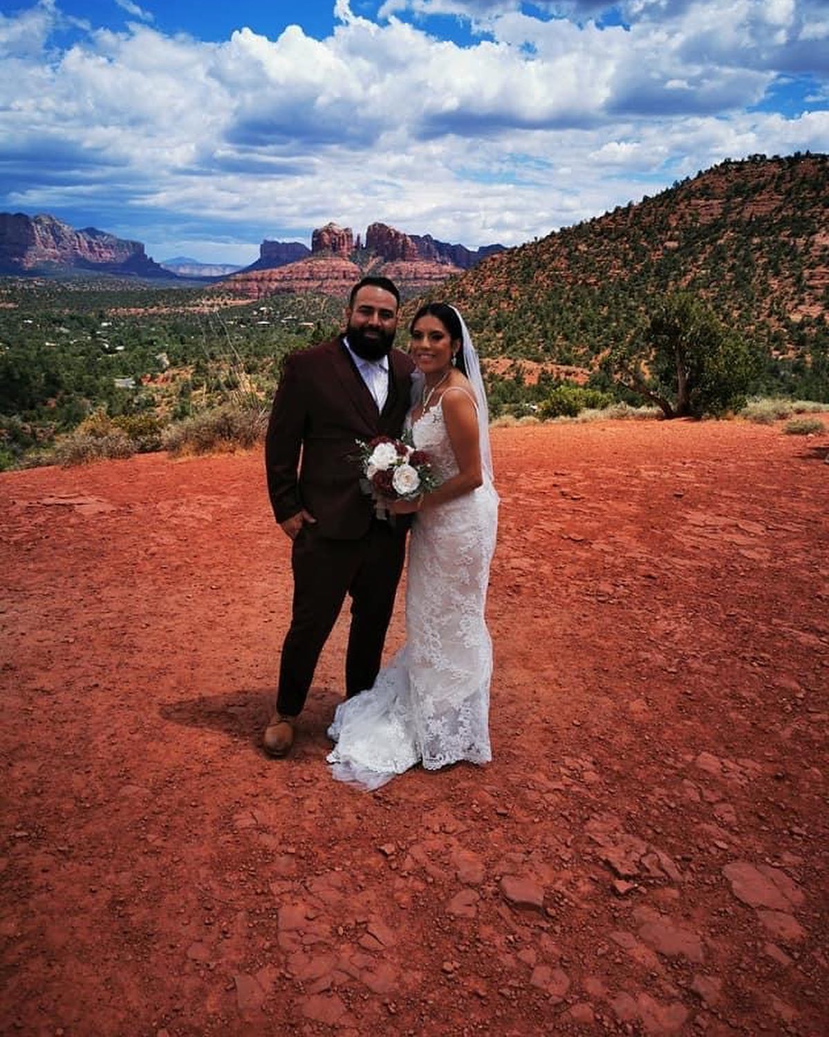 Brunette bride in white wedding dress and Groom near hills