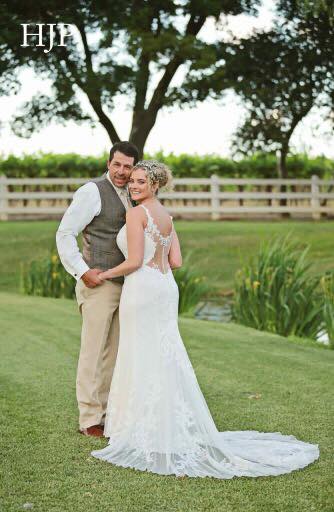 Groom and blonde bride in white wedding dress near pond
